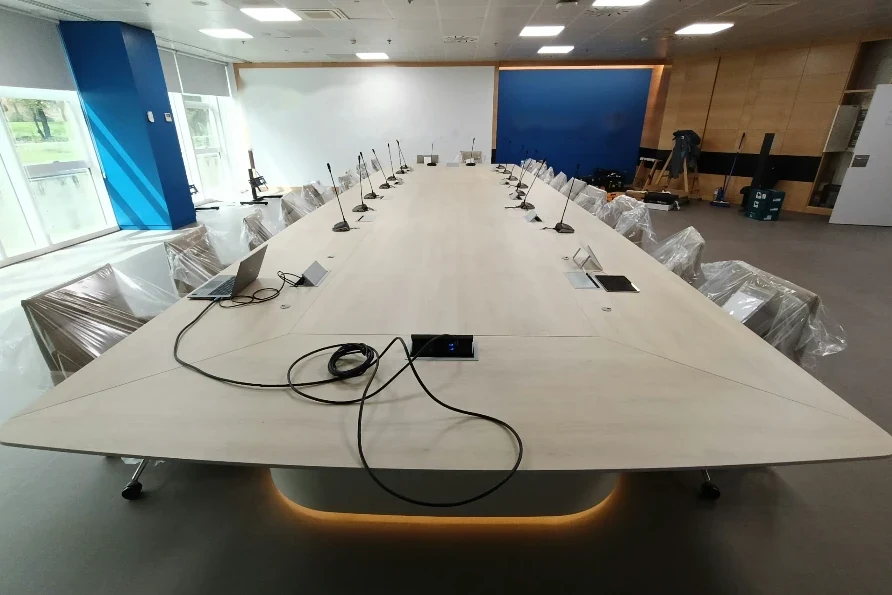 Boardroom table for more than 30 people with integrated connection boxes and microphones