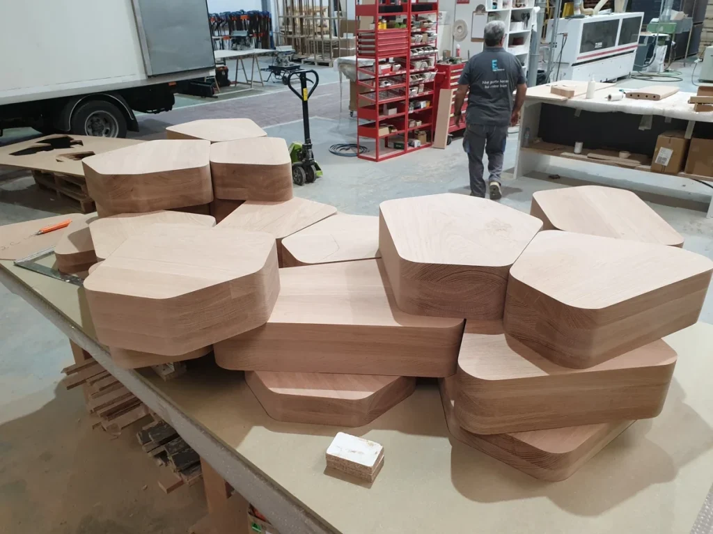 Machined polygonal solid oak pieces laid out on a bench in the Eban Premium workshop