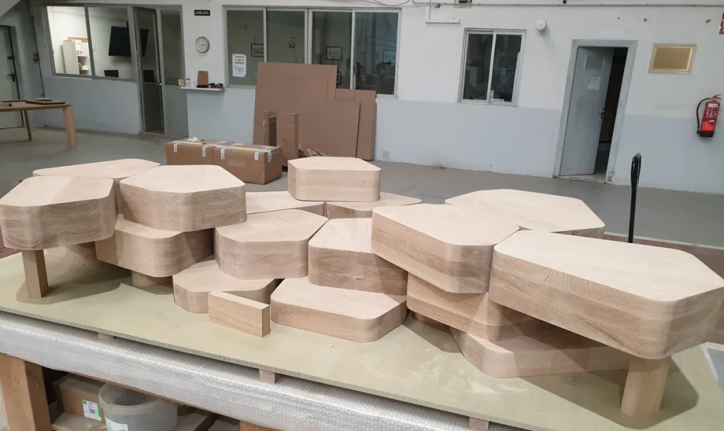 Table of polygonal solid oak pieces dry-assembled in the workshop before finishing