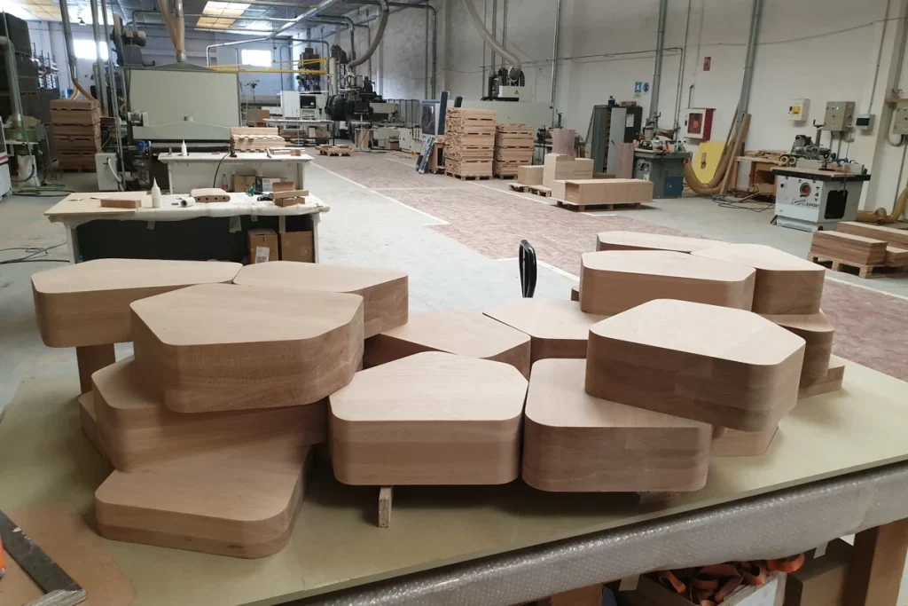 Solid oak pieces with rounded edges stacked at several heights in the Eban Premium factory