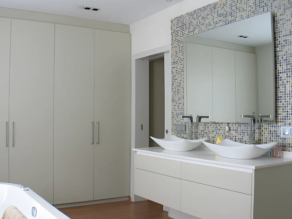 Baño con mueble de lavabo suspendido lacado, dos lavabos y armarios empotrados