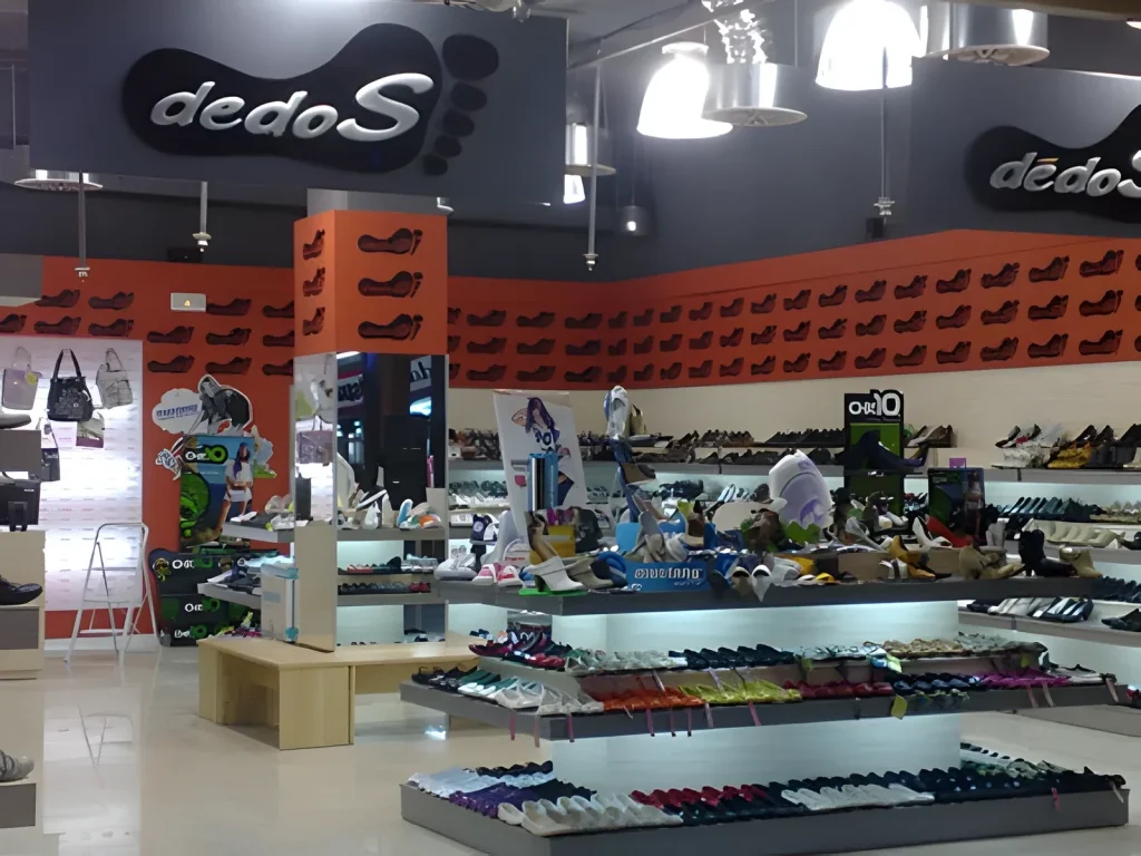 Zapatería con mesas expositoras iluminadas y lineales de pared fabricados a medida
